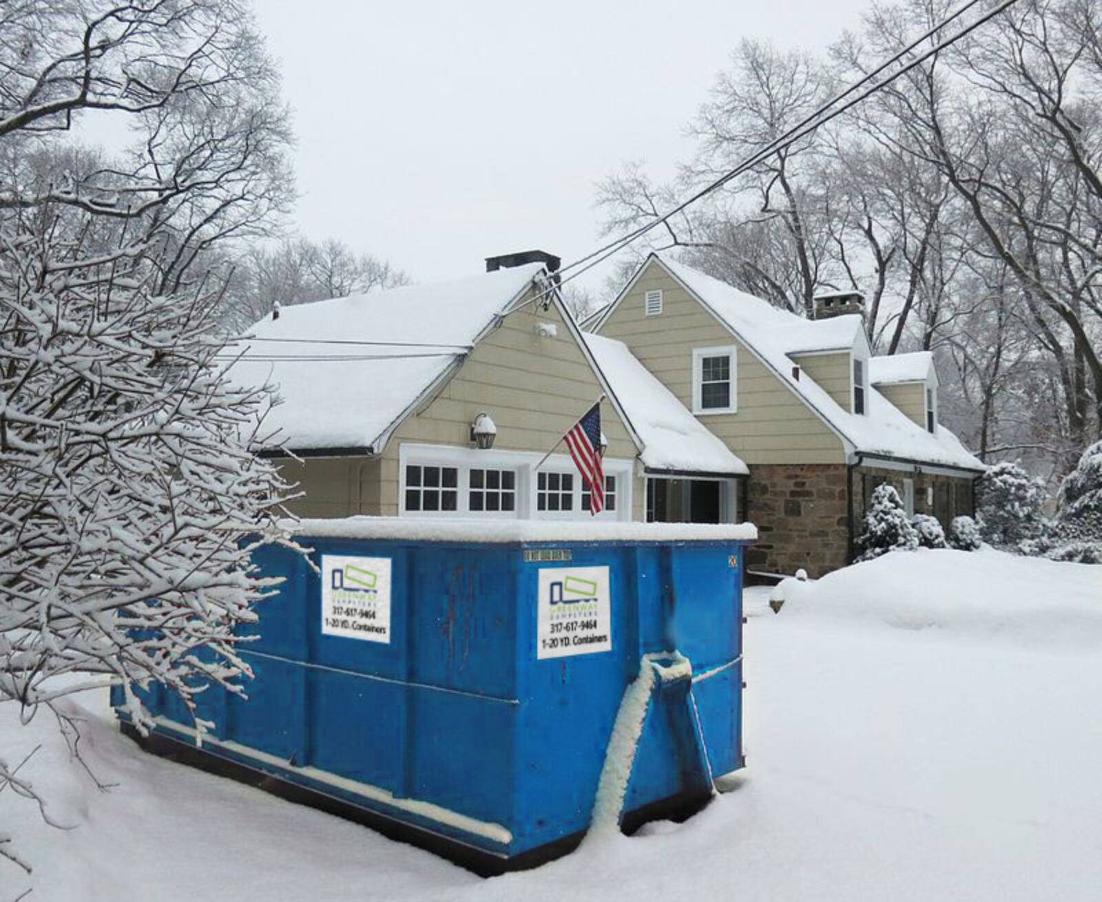 A 20-yard dumpster covered in snow during winter.