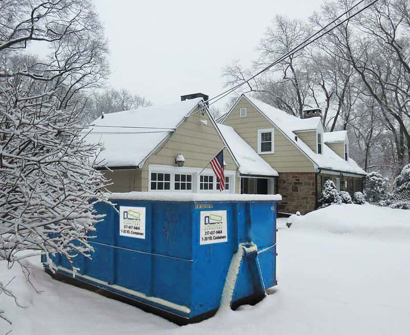 A 20-yard dumpster covered in snow during winter.