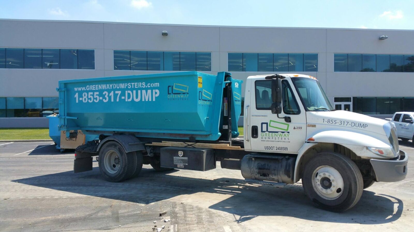 A clean Greenway dumpster on the back of a truck.