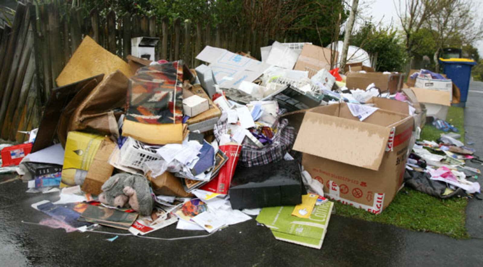Debris and materials left on the curb outside a house.