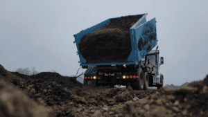 A truck tilting backward to unload debris packed in the back